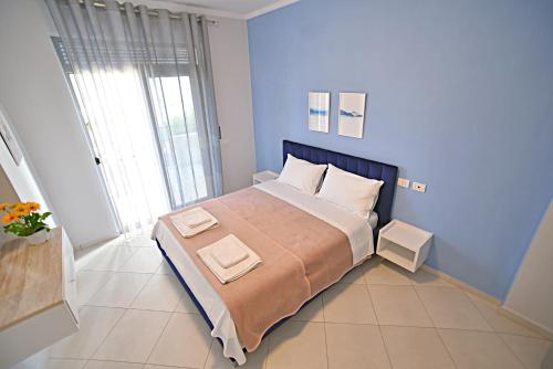 sypialnia z dużym łóżkiem i dwoma ręcznikami na nim w obiekcie SunRise Suites we Wlorze