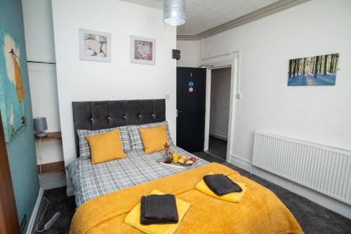 a bedroom with a large bed with yellow pillows at Bentley House with en-suites in Crewe