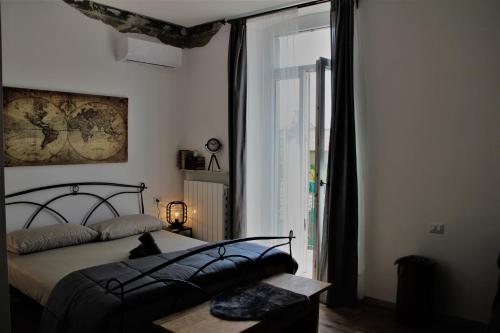 um quarto com uma cama e uma grande janela em Rial Maison em Bérgamo