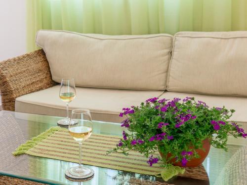 Green Home Apartments في كوتور: طاولة مع كأسين من النبيذ وأريكة