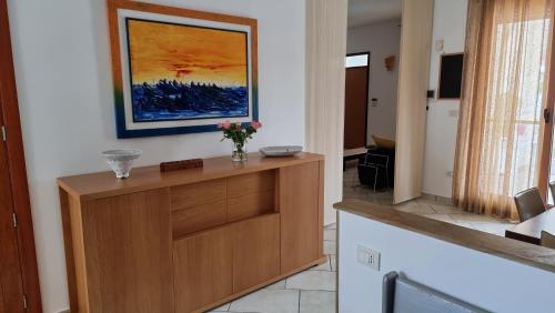 a kitchen with a wooden cabinet with a vase of flowers on it at Villa Vittoria in Mesagne