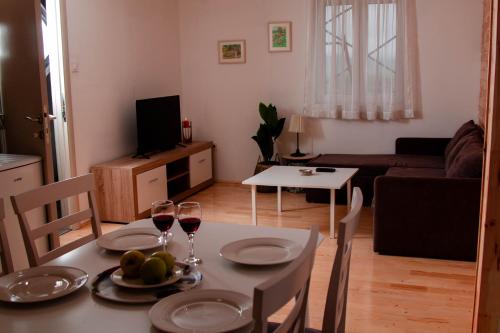 - un salon avec une table et deux verres de vin dans l'établissement Apartments Marta, à Žabljak