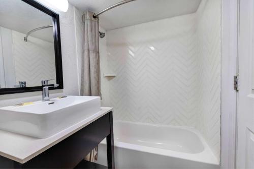 a white bathroom with a sink and a tub at Motel 6 Indianapolis, IN in Indianapolis