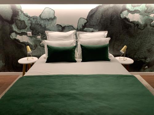 a bedroom with a green and white bed with two lamps at Pharmacia GuestHouse in Coimbra