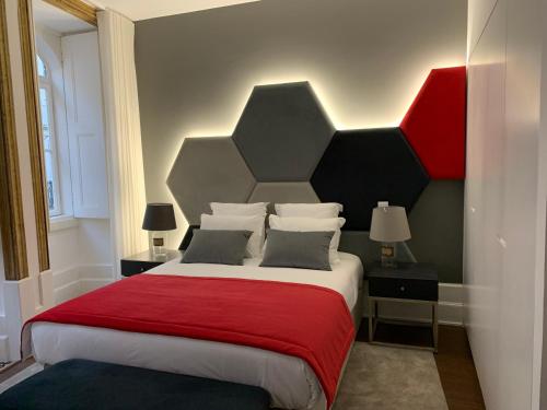 Pharmacia GuestHouse في كويمبرا: غرفة نوم بسرير كبير مع بطانية حمراء