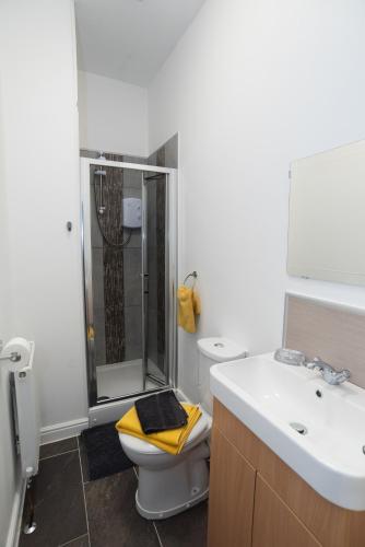 a bathroom with a shower and a toilet and a sink at Bentley House with en-suites in Crewe