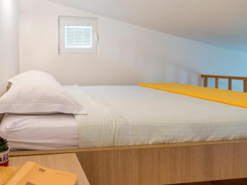 a bed with white sheets and a window in a room at Green Home Apartments in Kotor