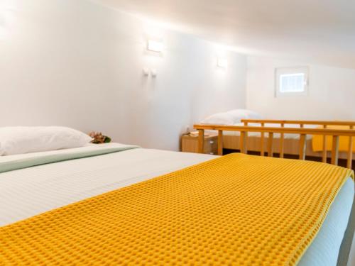 a bedroom with two beds and a yellow blanket on the bed at Green Home Apartments in Kotor