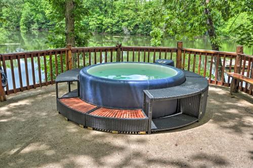 a large hot tub in a yard next to a fence at Remote Cabin on 30 Acres with Dock and Private Lake! in Macks Creek
