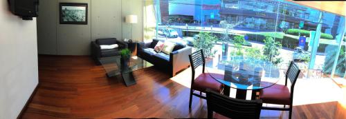 a living room with a couch and a glass table at Suites Aura For Living in Mexico City