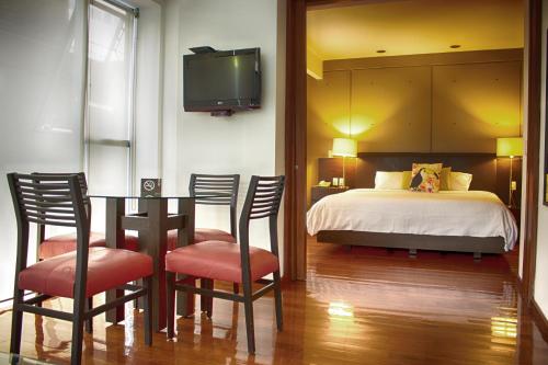 a bedroom with a bed and a table and chairs at Suites Aura For Living in Mexico City