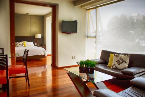 a living room with a couch and a bed at Suites Aura For Living in Mexico City