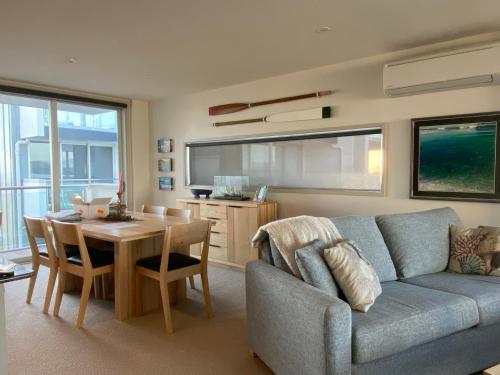 een woonkamer met een bank en een tafel bij Ohope Beach Resort in Ohope Beach
