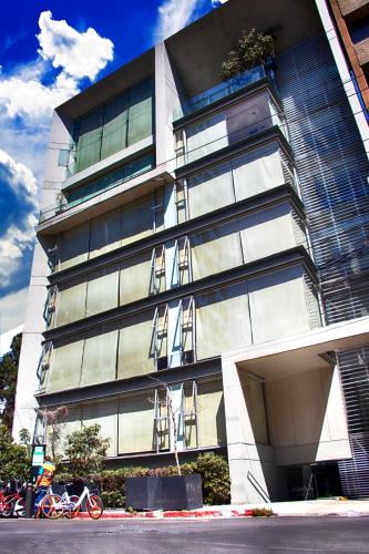 a building with chairs on the side of it at Suites Aura For Living in Mexico City