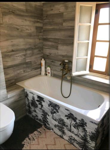 La salle de bains est pourvue d'une baignoire et de toilettes. dans l'établissement Loue maison de village à Hyères/ les Borrels, à Hyères