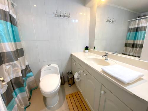a white bathroom with a toilet and a sink at Puerto Velero Primera Línea Primer Piso al lado de la Playa! 5 pax in Puerto Velero