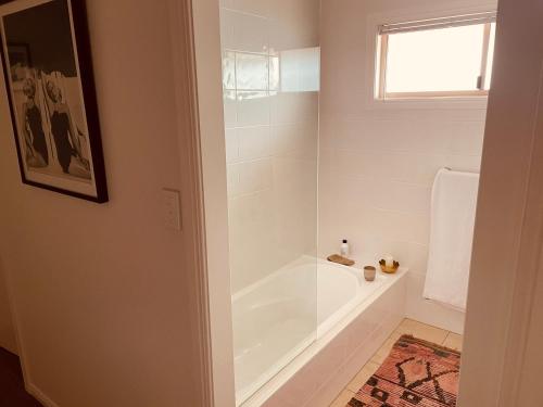 a bathroom with a shower and a bath tub at Byron Marvell in Byron Bay