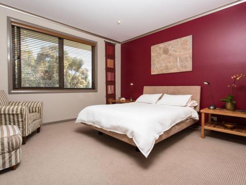 1 dormitorio con cama grande y pared morada en Tura Beachhouse in Dolphin Cove, en Tura Beach