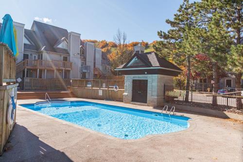 a swimming pool in front of a house at Blue Mountain Creekside Studio at North Creek Resort in Blue Mountains