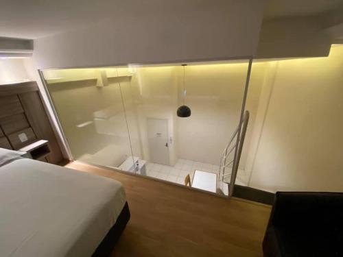 a room with a bed and a glass shower at Apart Hotel Eucalyptus in Telêmaco Borba