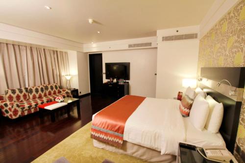 a hotel room with a bed and a couch at Crowne Plaza Pune City Centre by IHG in Pune
