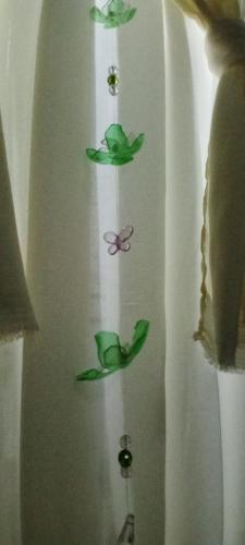 a curtain with green leaves and a butterfly on it at Chalé Rancho Aratama in Jacareí