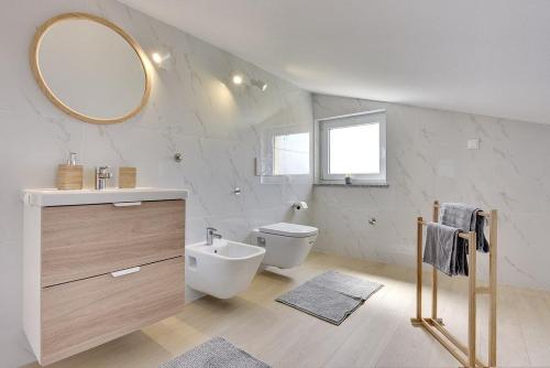 a bathroom with a sink and a toilet and a mirror at Apartments Sunset in Vodnjan