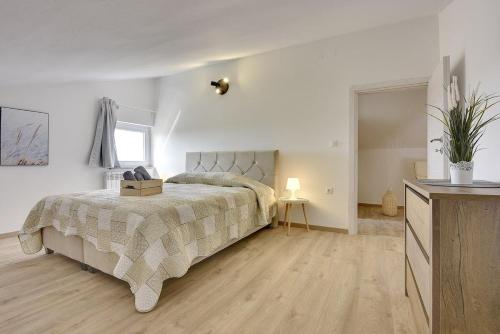 a bedroom with a bed and a dresser and a window at Apartments Sunset in Vodnjan