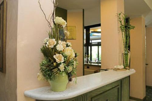 a vase of flowers on a counter in a bathroom at Hotel Kyrton in Forte dei Marmi