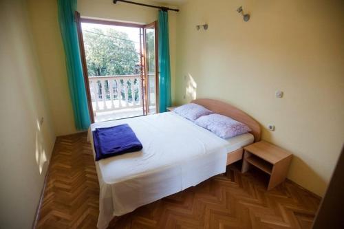 a small bedroom with a bed with a window at One-bedroom apartment with terrace in Povile 3542-4 in Povile