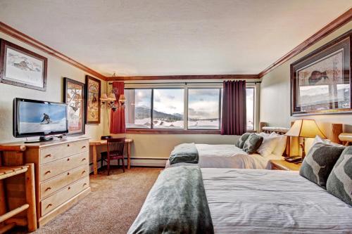 a hotel room with two beds and a flat screen tv at Beaver Run Resort - Peak 9 Penthouse in Breckenridge