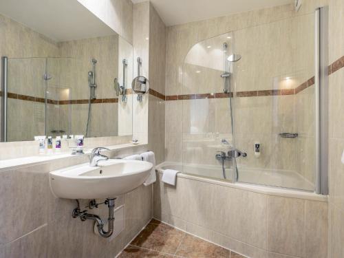 a bathroom with a sink and a shower and a tub at Mercure Hotel Berlin Mitte in Berlin