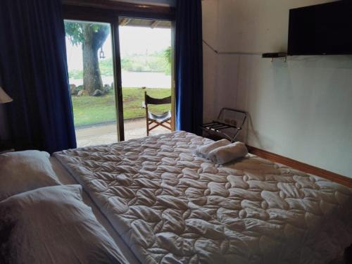 a large bed in a bedroom with a window at Casa Caletas Boutique Hotel in Puerto Coyote