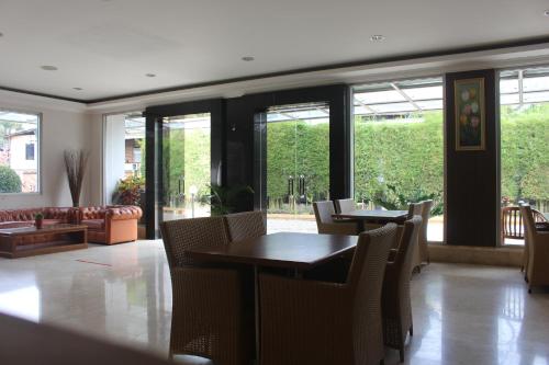 a dining room with tables and chairs and windows at HOTEL & WISMA BINTANG JADAYAT in Bogor