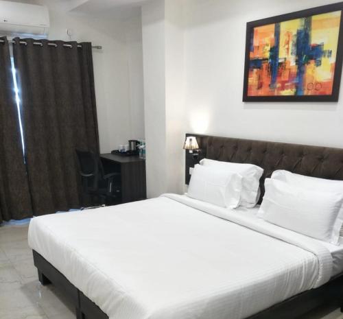 a bedroom with a large bed with white sheets at HOTEL CENTRUM in Kota