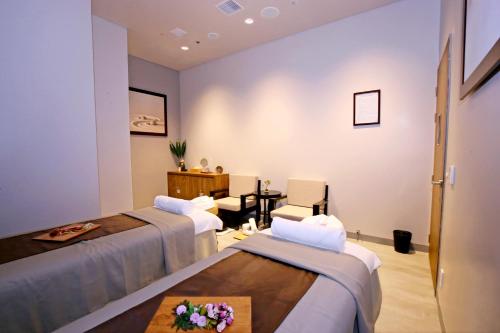 a hotel room with two beds and a table at Roygent Parks Hai Phong in Hai Phong