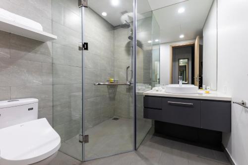 a bathroom with a shower and a toilet and a sink at Roygent Parks Hai Phong in Hai Phong