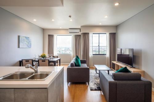 a kitchen and living room with a sink and a couch at Roygent Parks Hai Phong in Hai Phong