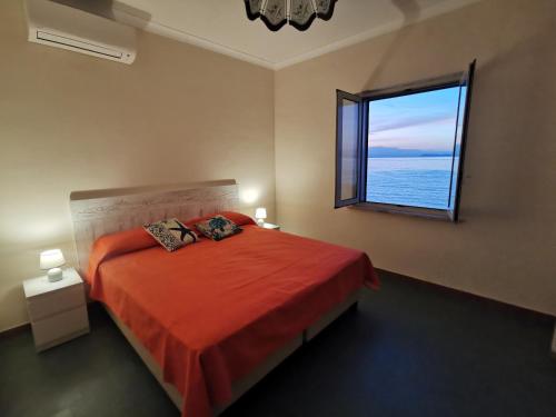 a bedroom with a red bed and a window at Brezza Marina in Massa Lubrense