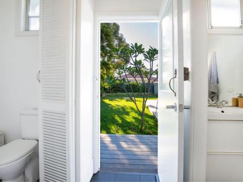 a bathroom with a toilet and a view of a yard at Beachwood - Firepit - Pet Friendly - 2 Mins Walk to the Beach in Callala Beach