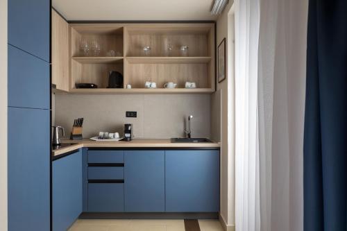 a kitchen with blue cabinets and a sink at Istrian Villas Plava Laguna in Umag
