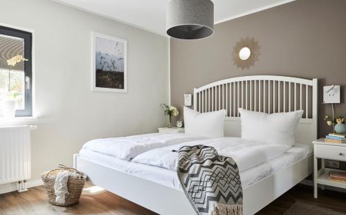 a bedroom with a white bed with a wooden headboard at Haus Ostsee in Göhren