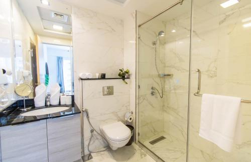 a bathroom with a shower and a toilet and a sink at Stella Stays Bold 1 BDR Dubai JVC Private Balcony in Dubai