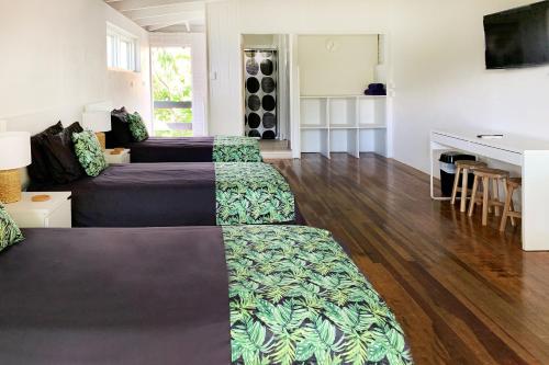 a living room with two beds and a table at Airlie Beach Magnums - Adults Only in Airlie Beach