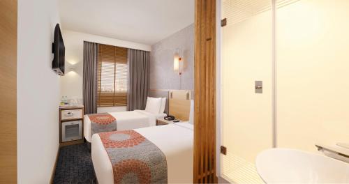 a hotel room with two beds and a bathroom at Holiday Inn Express Hyderabad Banjara Hills, an IHG Hotel in Hyderabad