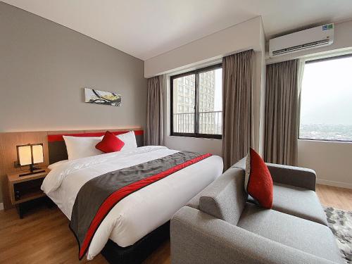 a hotel room with a bed and a couch at Roygent Parks Hai Phong in Hai Phong