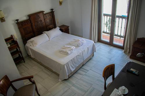 a bedroom with a bed with towels on it at Hotel Playa de Regla in Chipiona