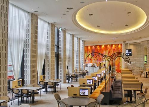 a restaurant with tables and chairs in a building at Lotte Buyeo Resort in Buyeo