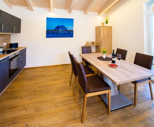 a kitchen and dining room with a wooden table and chairs at Appartement Elisabeth in Neukirchen am Großvenediger