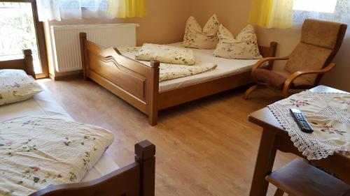 a bedroom with two beds and a table and chairs at U Kaśki in Biały Dunajec
